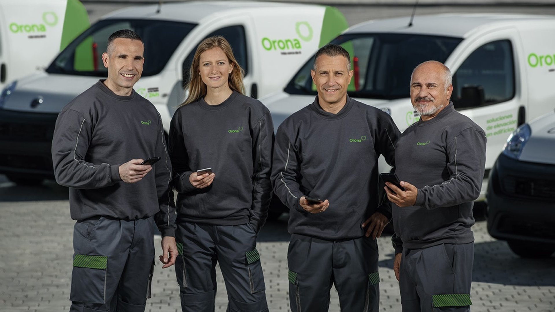 Team von Männern und Frauen mit Autos im Hintergrund