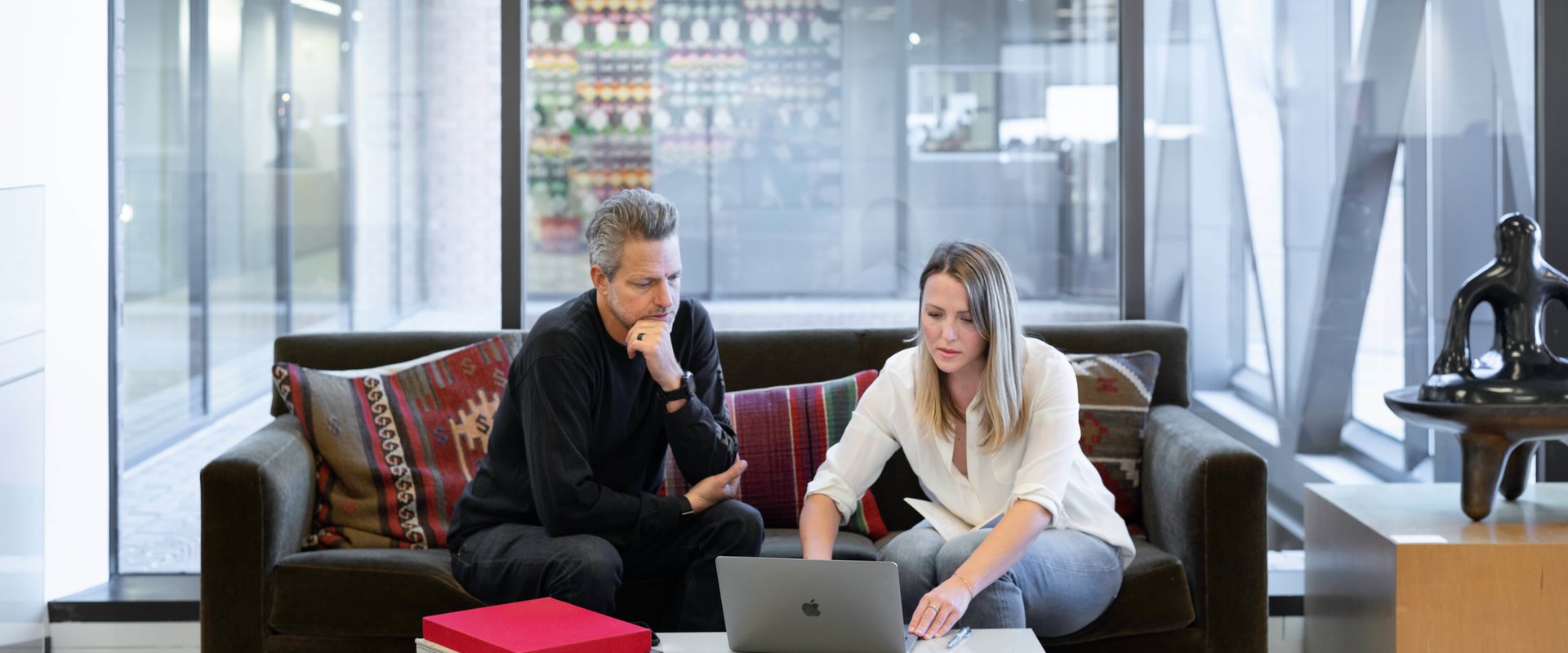 homme et femme avec un ordinateur dans un grand bureau